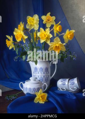 Still life with bouquet of yellow daffodils on a tea table Stock Photo