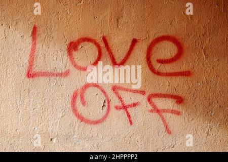 LOVE OFF. The inscription on the plastered wall with lipstick. Cry of the soul Stock Photo