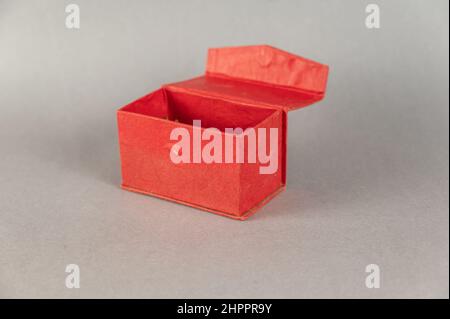 Empty Open red rectangular box on gray background. Close-up. Selective focus. Stock Photo