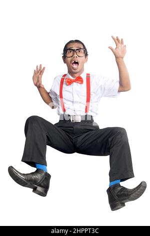 Asian nerd with ugly face falling isolated over white background Stock Photo
