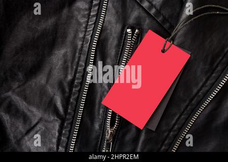 Empty label for text in red color on leather black jacket with metal locks Stock Photo