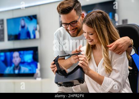 Portrait of happy people having fun with virtual reality glasses. Couple using new vr headset Stock Photo