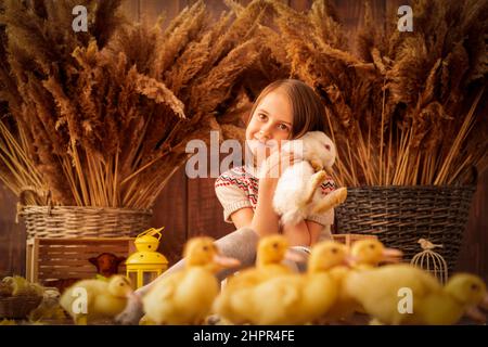 Easter portrait of hapy young beautiful girl with white rabbit. Stock Photo