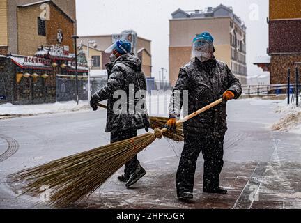 Beijing, China. 13th Feb, 2022. Workers in protective masks against COVID-19 remove snow in Beijing during the 2022 Winter Olympics, China, February 13, 2022. Credit: Roman Vondrous/CTK Photo/Alamy Live News Stock Photo