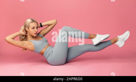 Young Woman Doing Abs Exercise, Side Crunches Stock Photo