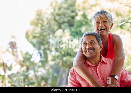 Never stop playing. Shot of a carefree senior couple enjoying a piggyback ride outdoors. Stock Photo
