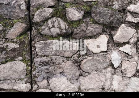 Abstract traditional stone wall pavement texture background. Bumpy textured stonewall made from flagstone and slabstone. Stock Photo
