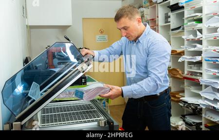 Worker packs notebooks in a vacuum packing Stock Photo