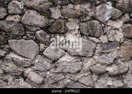 Abstract traditional stone wall pavement texture background. Bumpy textured stonewall made from flagstone and slabstone. Stock Photo