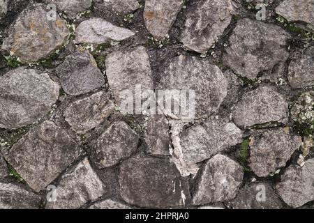 Abstract traditional stone wall pavement texture background. Bumpy textured stonewall made from flagstone and slabstone. Stock Photo