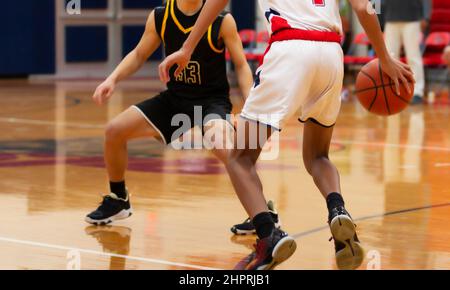 Two high school basketball players going one on one during a game. Stock Photo