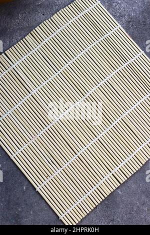 Sushi Roller mat on grey grainy background. Stock Photo