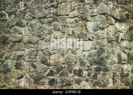 Abstract traditional stone wall pavement texture background. Bumpy textured stonewall made from flagstone and slabstone. Stock Photo