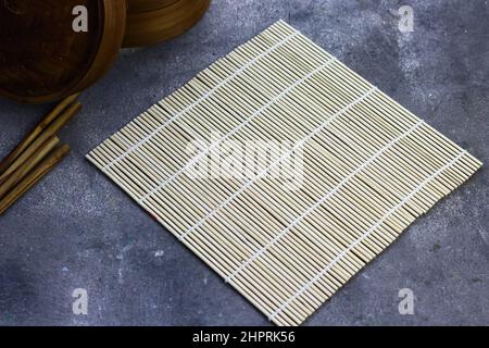Sushi Roller mat on grey grainy background. Stock Photo