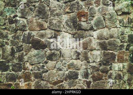 Abstract traditional stone wall pavement texture background. Bumpy textured stonewall made from flagstone and slabstone. Stock Photo