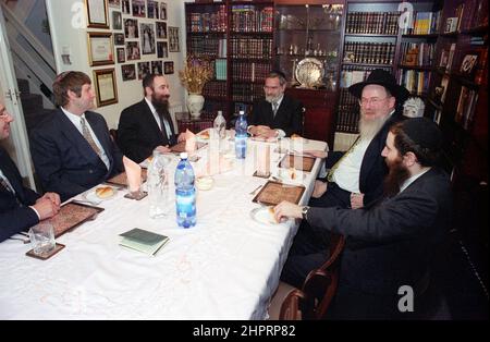 The Chief Rabbi Jonathan Sacks was the guest of honour for the celebration of the Solihull Hebrew Congregation's 25th Anniversary. During his visit he met children in the lounge of a family from the congregation. He talks informally to young Jewish children about their work achieved at the synagogue's Cheder (classroom), minister of the congregation Rabbi Yehuda Pink looks on. He spoke during  the religious service on 27th October 2002.The Mayor of Solihull Cllr. Kate Wild attended and was presented with a bouquet from Cheder pupil 13 year old Zipporah Gershon Stock Photo