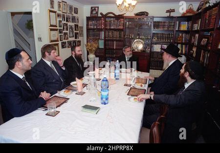 The Chief Rabbi Jonathan Sacks was the guest of honour for the celebration of the Solihull Hebrew Congregation's 25th Anniversary. During his visit he met children in the lounge of a family from the congregation. He talks informally to young Jewish children about their work achieved at the synagogue's Cheder (classroom), minister of the congregation Rabbi Yehuda Pink looks on. He spoke during  the religious service on 27th October 2002.The Mayor of Solihull Cllr. Kate Wild attended and was presented with a bouquet from Cheder pupil 13 year old Zipporah Gershon Stock Photo