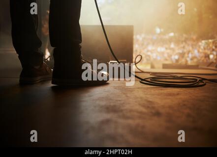 Ready to rock. Cropped shot of a musicians feet on stage at an outdoor music festival. Stock Photo