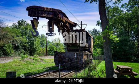 View of a Rusting of Train Steam Crane sitting on a Track Rusting Away on a Sunny Day Stock Photo