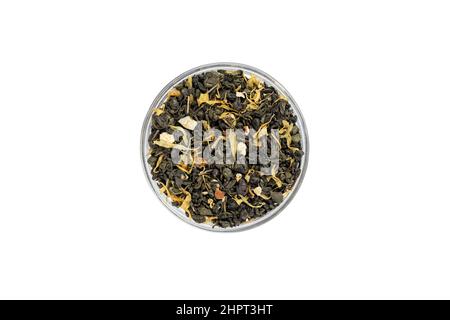 Dry leaf green tea with pieces of dried fruits in a bowl isolated on white background from above. Glass saucer. Top view Stock Photo