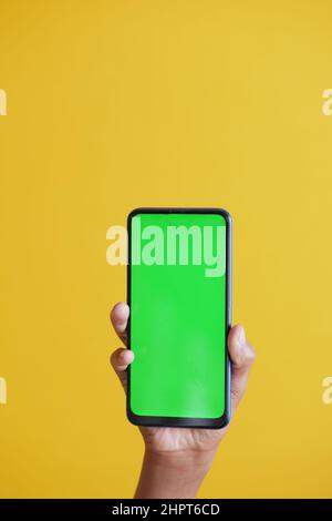 Close up of young man hand using smart phone with green screen  Stock Photo