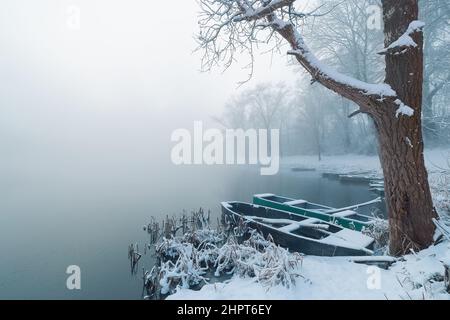 Boats anchored on the shore of lake on a cold frosty winter morning