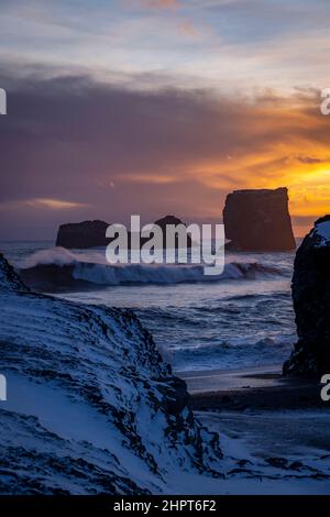 view of rocks and stormy sea at sunset from Dyrholaey Peninsula, southeast Iceland Stock Photo