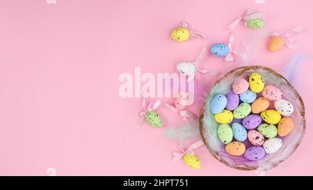 Happy Easter creative copy space background with colorful eggs and Easter decorations on pastel pink theme. Flat lay minimal Stock Photo
