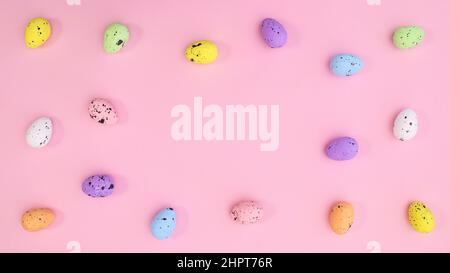Copy space pastel pink background pattern with colorful eggs on pastel pink theme. Bright trendy flat lay composition. Stock Photo
