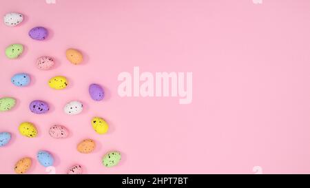 Easter copy space background with colorful eggs on pastel pink theme. Flat lay minimal creative layout. Stock Photo