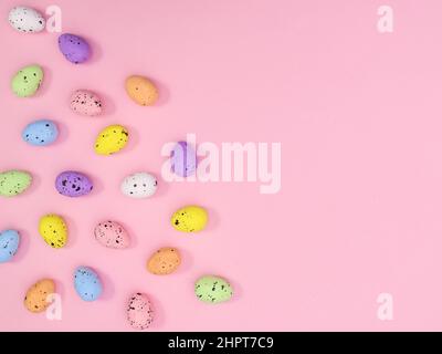 Easter copy space background with colorful eggs on pastel pink theme. Flat lay minimal creative layout. Stock Photo