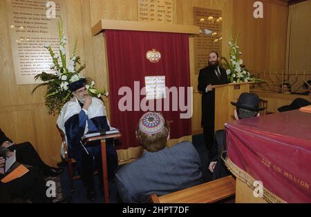 The Chief Rabbi Jonathan Sacks was the guest of honour for the celebration of the Solihull Hebrew Congregation's 25th Anniversary. During his visit he met children in the lounge of a family from the congregation. He talks informally to young Jewish children about their work achieved at the synagogue's Cheder (classroom), minister of the congregation Rabbi Yehuda Pink looks on. He spoke during a the commemoration n service on 27th October 2002.The Mayor of Solihull Cllr. Kate Wild attended and was presented with a bouquet from Cheder pupil 13 year old Zipporah Gershon Stock Photo