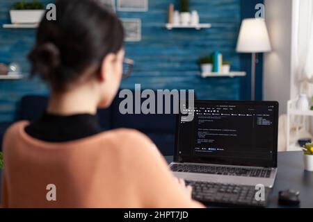 Freelancer programming software on laptop. Programmer working remote from home office. Code tester debugging on laptop using keyboard. Student developer typing data on screen. Stock Photo