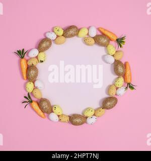 Creative paper card copy space with Easter eggs frame on pastel pink background. Spring holidays bright trendy greeting card. Stock Photo