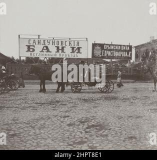 Vintage photo of row of  horse-drawn carriages (britzka) with passengers, standing in front of billboards of famous Sandunóvskie Baths (Sanduny) on  N Stock Photo