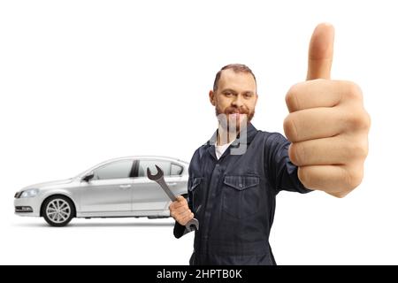 Car mechanic gesturing thumbs up and holding a wrench isolated on white background Stock Photo