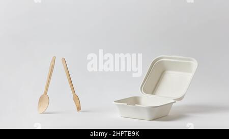 empty clean open white paper food box and wooden fork and spoon on white background Stock Photo