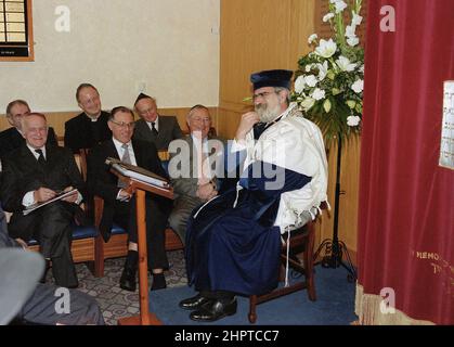 The Chief Rabbi Jonathan Sacks was the guest of honour for the celebration of the Solihull Hebrew Congregation's 25th Anniversary. During his visit he met children in the lounge of a family from the congregation. He talks informally to young Jewish children about their work achieved at the synagogue's Cheder (classroom), minister of the congregation Rabbi Yehuda Pink looks on. He spoke during a the commeration service on 27th October 2002.The Mayor of Solihull Cllr. Kate Wild attended and was presented with a bouquet from Cheder pupil 13 year old Zipporah Gershon Stock Photo