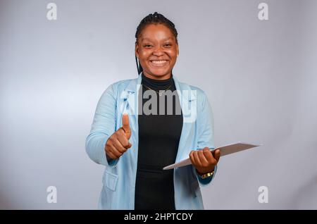 Beautiful African travel agent showing thumbs up Stock Photo