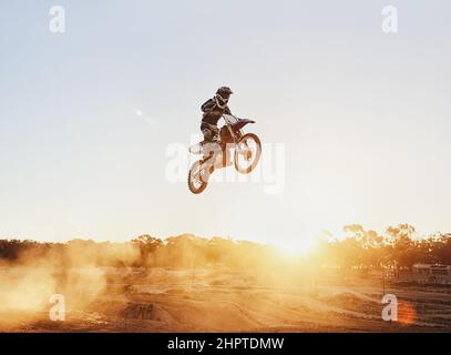 Hes flying through the air. A shot of a motocross rider in midair during a race. Stock Photo