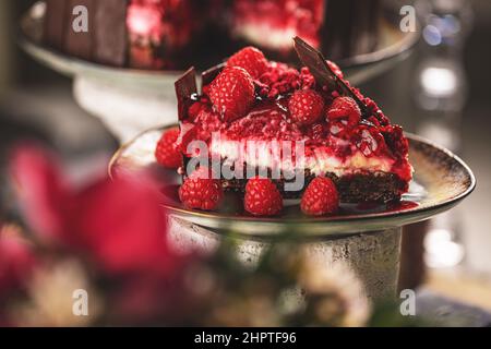Slice of chocolate cake with raspberries decorated with chocolate shards Stock Photo