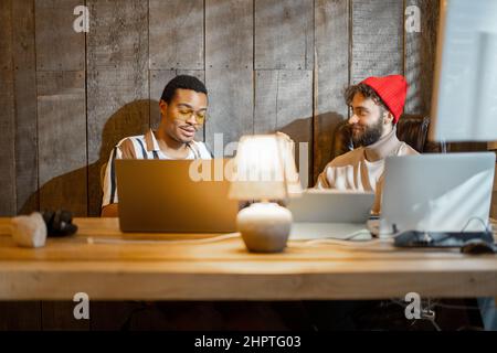 Gay couple working on computers at home office Stock Photo