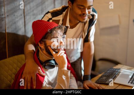 Gay couple working on computers at home office Stock Photo