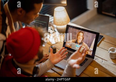 Stylish gay couple having video call with female colleague Stock Photo