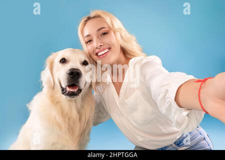 Young woman with her dog taking selfportrait Stock Photo