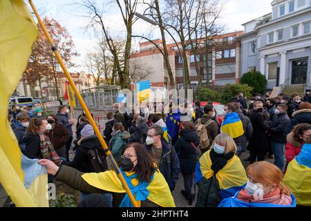 Hamburg, Germany. 23rd Feb, 2022. Demonstrators stand with placards and flags in front of the Russian consulate. According to police, about 200 people gathered in front of the Russian Consulate General in Hamburg on Wednesday for a solidarity rally with Ukraine. The Hamburg youth organizations of the SPD, Greens, CDU and FDP had called for the rally. Credit: Jonas Walzberg/dpa/Alamy Live News Stock Photo