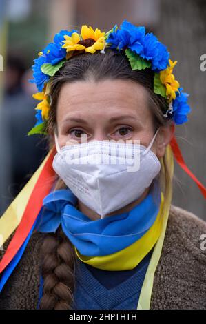 Hamburg, Germany. 23rd Feb, 2022. A demonstrator wears a wreath of hair in the colors of the Ukrainian national flag. According to police, about 200 people gathered in front of the Russian Consulate General in Hamburg on Wednesday for a solidarity rally with Ukraine. The Hamburg youth organizations of SPD, Greens, CDU and FDP had called for the rally. Credit: Jonas Walzberg/dpa/Alamy Live News Stock Photo