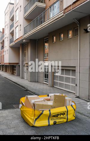 A hippo waste skip bag ready for collection from a street location surrounded by high-rise residential buildings. Stock Photo