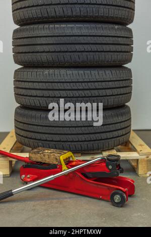Close up view of car wheels lying on pallet with jack for changing tires. Sweden. Stock Photo