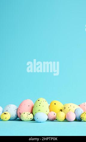 Row of painted colored easter eggs on blue background. Happy Easter background. Stock Photo